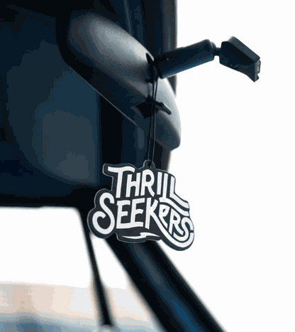 Thrill Seekers Paradise black and white car air freshener hanging from rearview mirror